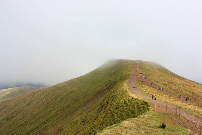 view-of-pen-y-fan-peak-from-corn-du-and-clouds-and-mountain-hikers